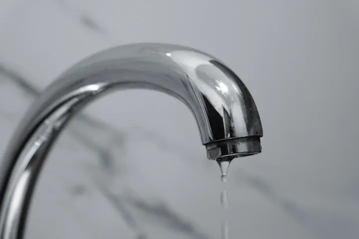 Water dripping from a chrome bathroom faucet