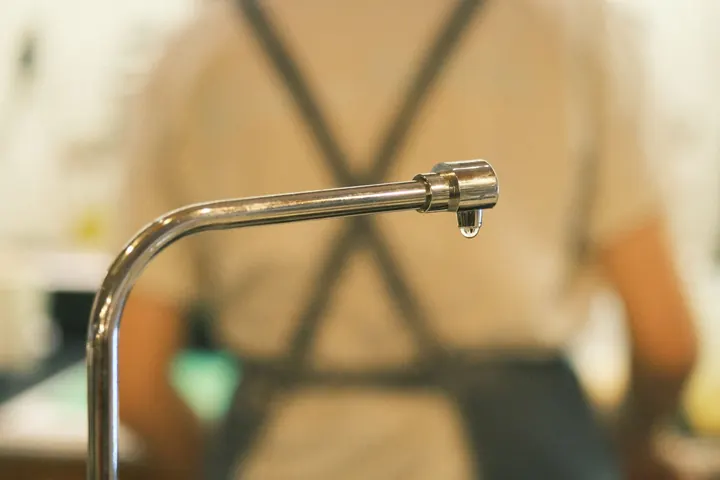 Close view of a dripping faucet indoors