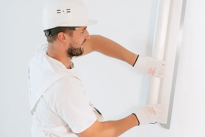 Worker installing drywall inside a home