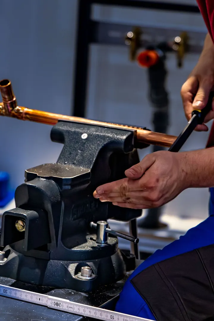 Plumber bending a copper water pipe