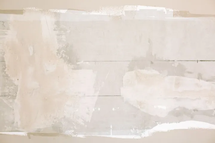 Unfinished wall with plaster and paint patches
